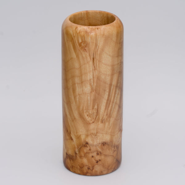 Figured maple wood shot glass against white background