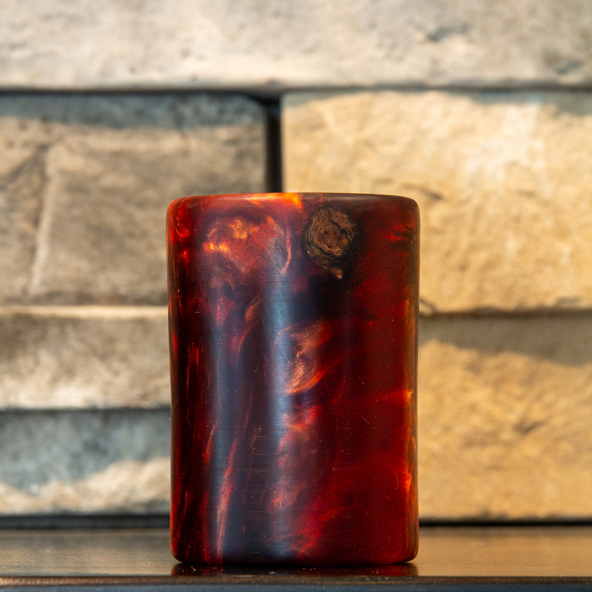 Exterior view of grapevine and wine-red resin shot glass with an eye-shaped wood knot near the rim and deep translucent red resin