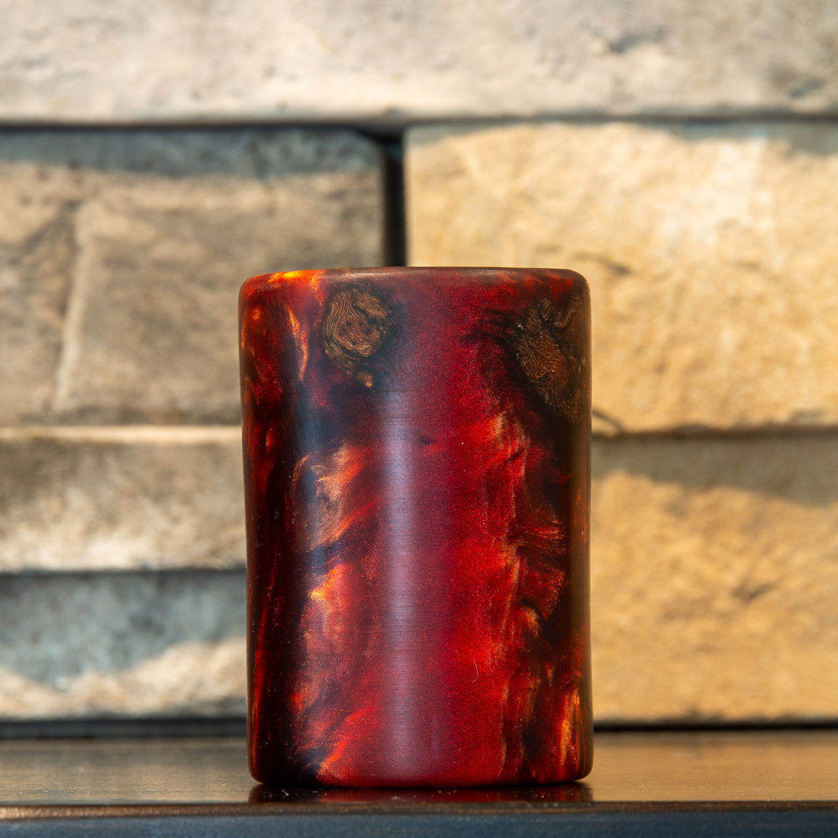Grapevine and wine-red resin shot glass showing two small patterned wood sections near the rim and a luminous red resin field