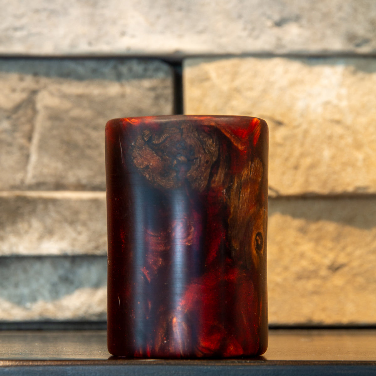 Rotated view of grapevine and wine-red resin shot glass showing a broad irregular wood cluster across the upper half