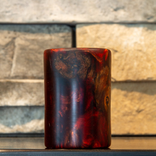 Rotated view of grapevine and wine-red resin shot glass showing a broad irregular wood cluster across the upper half