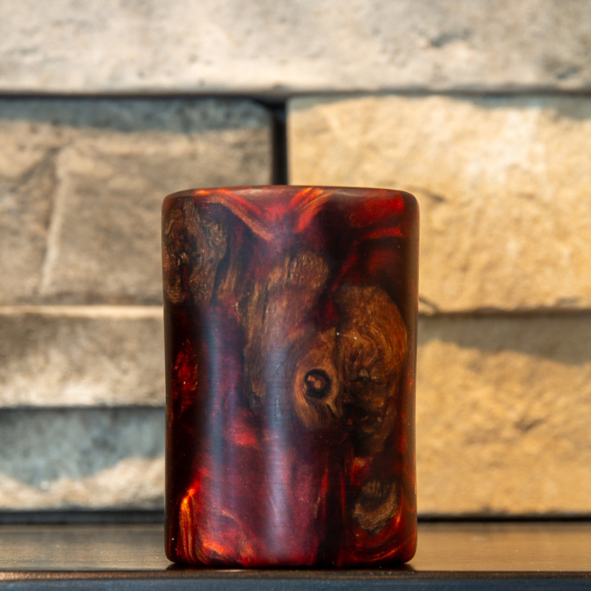 Grapevine and wine-red resin shot glass with a large oval wood figure, circular knot, and translucent red surrounding the natural form 