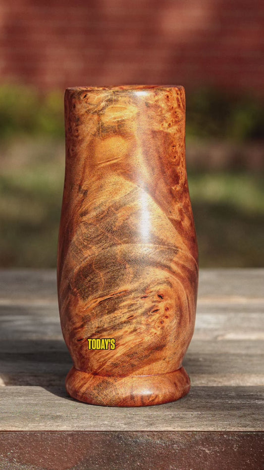 Video of The Unwritten Grain, a hand-turned Amboyna burl shot glass, showing its tall Glencairn-inspired form, warm reddish-brown and golden-brown coloration, clustered burl eyes, and sweeping dark grain patterns from multiple angles.
