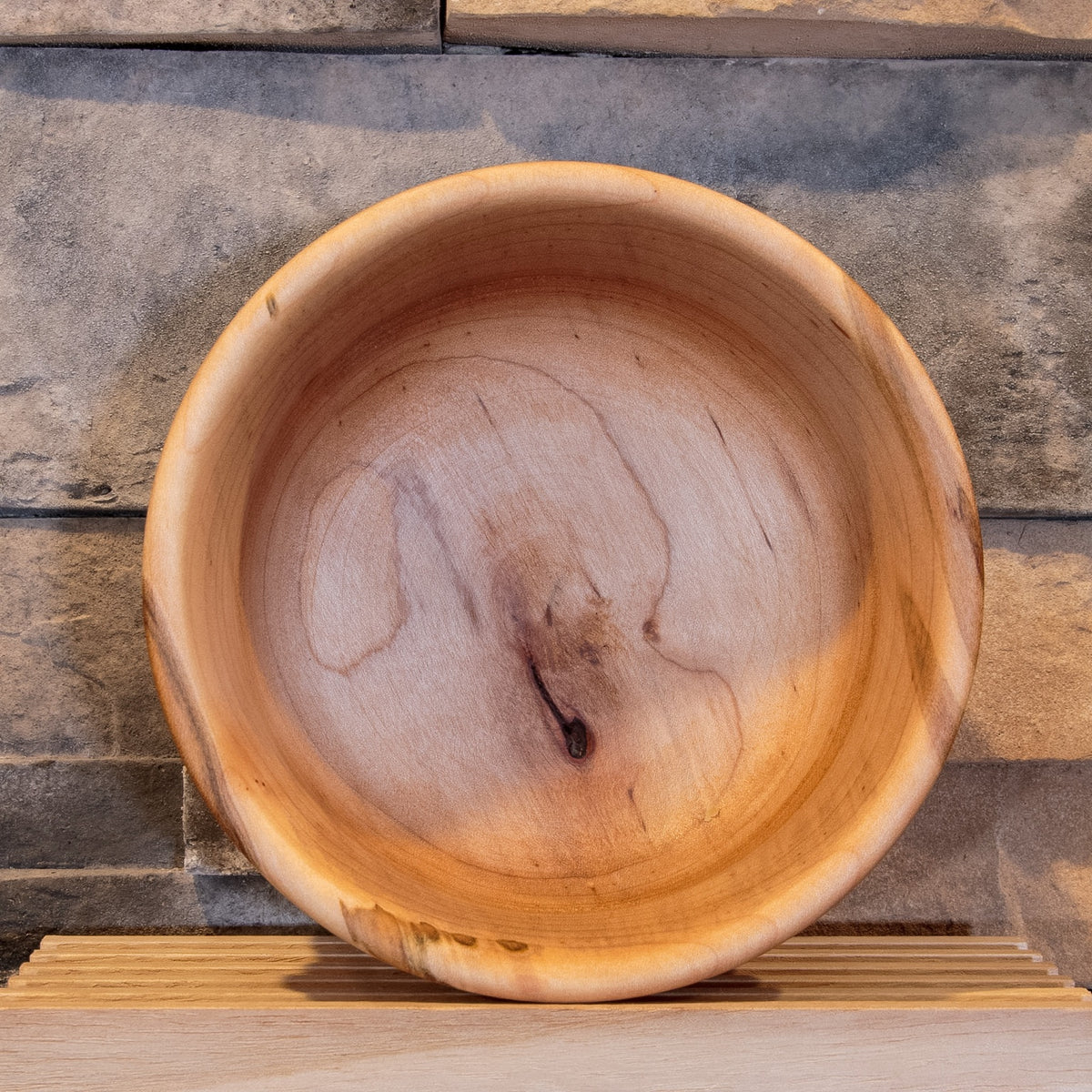 Interior of The Final Pass Maple bowl showing broad grain, warm color variation, and a dark natural feature