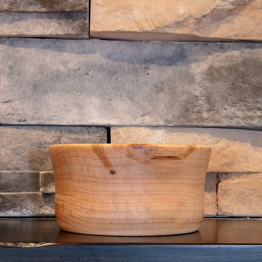The Final Pass Maple bowl showing darker natural figure near the rim and a small knot across one exterior face