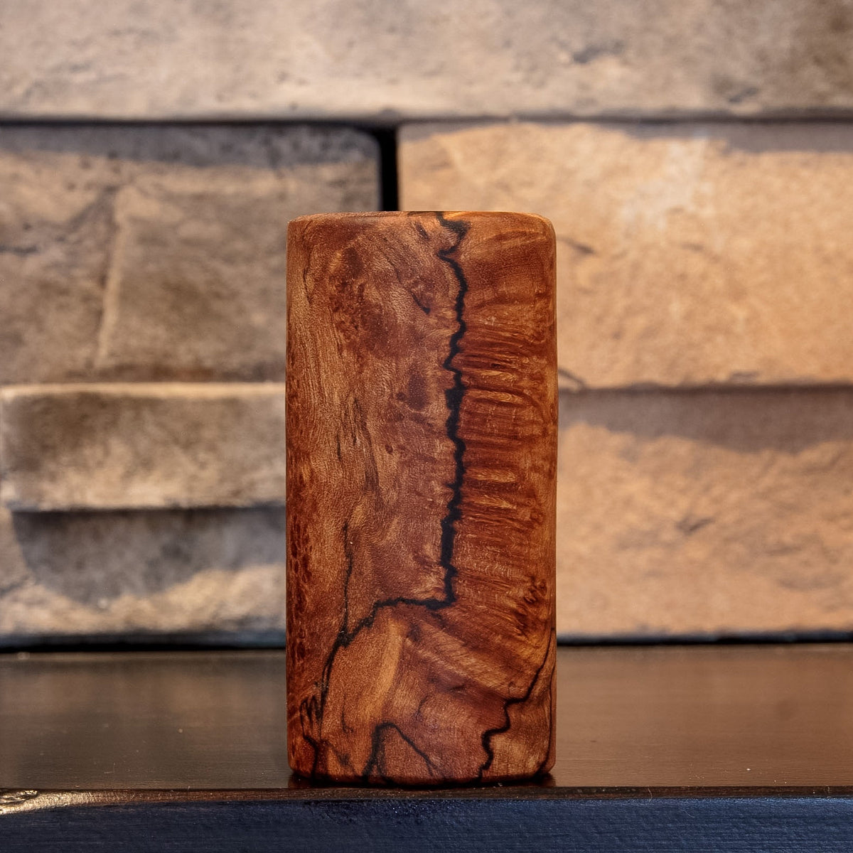 The Long Game shot glass with a strong vertical spalting line dividing contrasting Bigleaf Maple burl figure