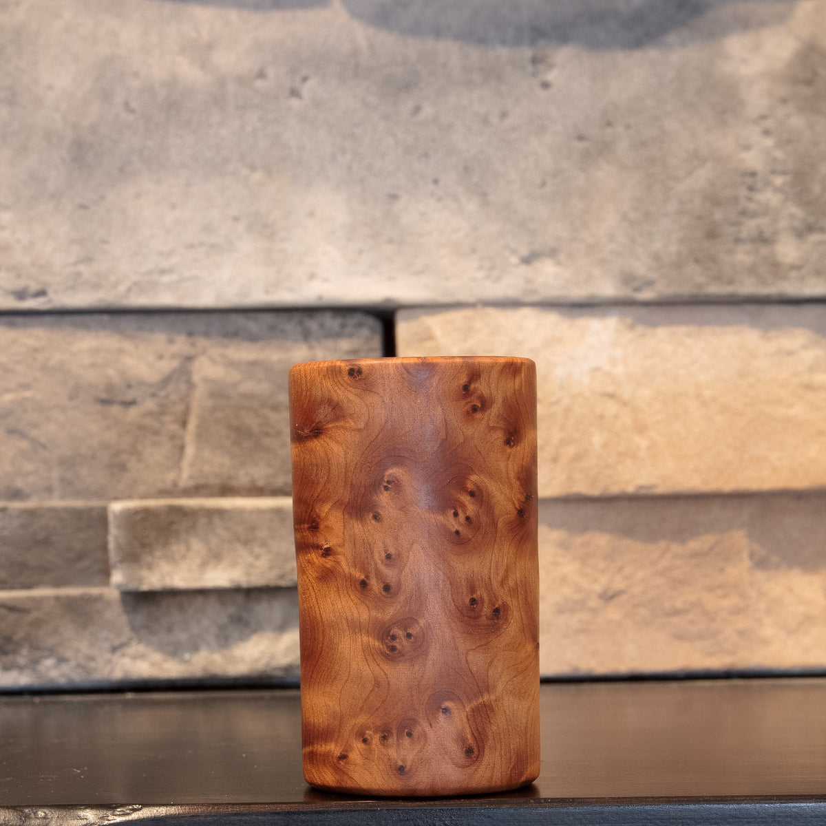 The Scented Testament Thuya Burl shot glass showing dense clustered burl eyes across warm amber grain 